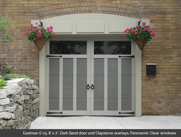 Eastman E-13 Dark Sand Garaga garage doors with Claystone overlays and Panoramic clear windows